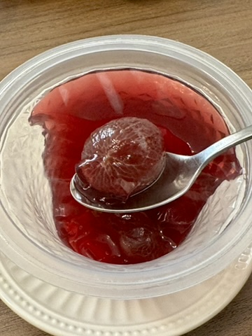 ゼリーの中のぶどうをスプーンですくった写真